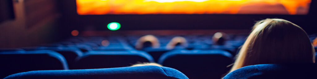 Mother and daughter watching a movie at a theater